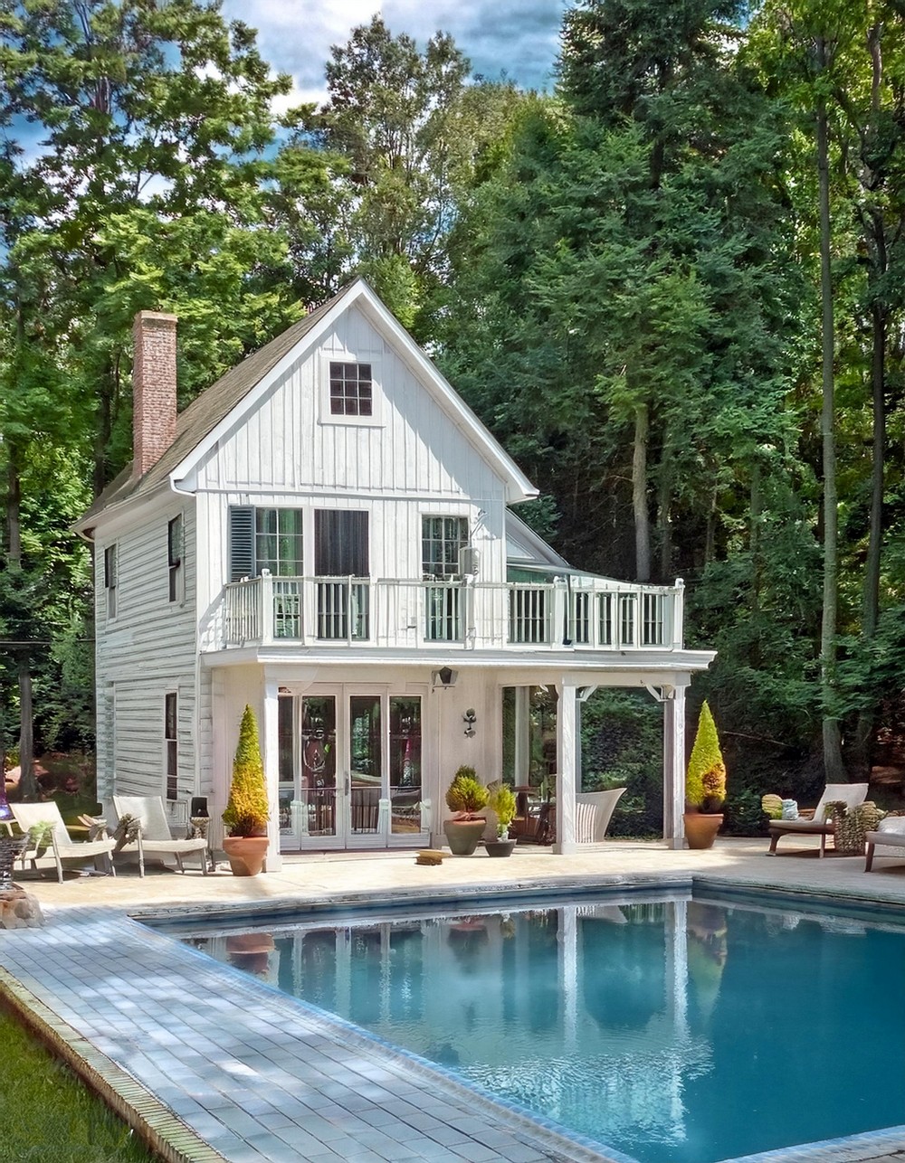 Farmhouse Pool House with a Whitewashed Exterior